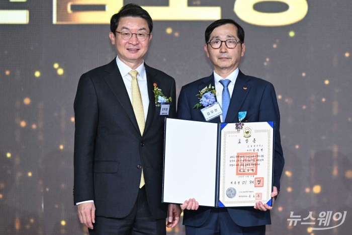 이억원 금융위원장이 31일 오후 서울 여의도 FKI타워에서 열린 회계의 날 기념식에서 김우현 SK하이닉스 부사장에게 산업포장을 수여한 뒤 기념촬영을 하고 있다. 사진=강민석 기자 kms@newsway.co.kr