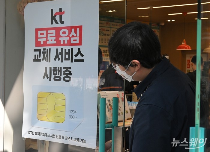 KT가 해킹 피해 후속 대책으로 전 가입자를 대상으로 유심(USIM) 무상 교체를 시작한 5일 서울 KT플라자 여의도역점에서 무료 유심(USIM) 교체 서비스 시행 안내문을 부착하고 있다. 사진=이수길 기자 Leo2004@newsway.co.kr