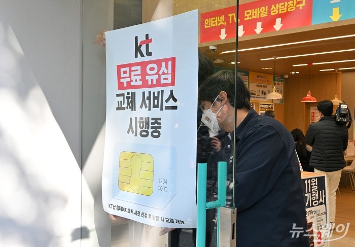 KT가 해킹 피해 후속 대책으로 전 가입자를 대상으로 유심(USIM) 무상 교체를 시작한 5일 서울 KT플라자 여의도역점에서 무료 유심(USIM) 교체 서비스 시행 안내문을 부착하고 있다. 사진=이수길 기자 Leo2004@newsway.co.kr