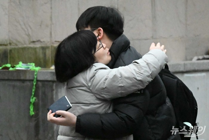 2026학년도 대학수학능력시험(수능)이 치러진 13일 오전 서울 종로구 경복고등학교에 마련된 고사장 정문에서 학부모와 수험생이 포옹을 나누고 있다. 사진=강민석 기자 kms@newsway.co.kr
