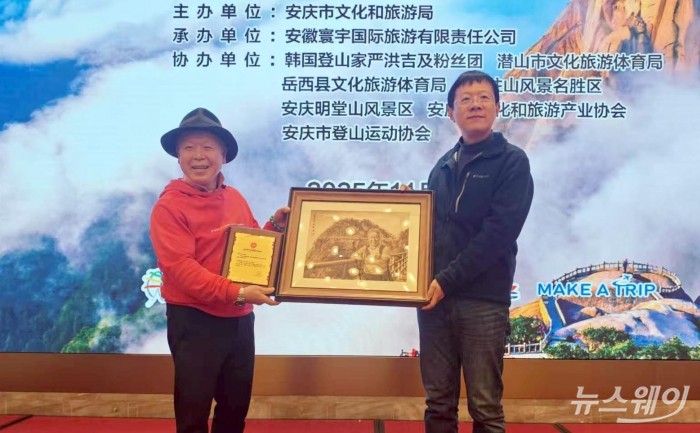 (왼쪽)엄홍길 산악인이 지난 2일 중국 안경시에서 열린 천주산(天柱山)과 명당산(明堂山) 홍보대사 위촉식에서 장신(张晨) 안경시 문화여유국 국장으로부터 위촉패를 수상한 뒤 기념촬영을 하고 있다. 사진=㈜여행을만들다