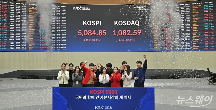 최초로 종가 기준 코스피 5000을 달성한 27일 서울 영등포구 한국거래소에서 직원들이 코스피 종가가 표시된 전광판을 배경으로 세레머니를 하고 있다. 이날 코스피지수는 전일대비 135.26p(2.73%) 오른 5084.85로 장을 마감했다. 사진=이수길 기자 Leo2004@newsway.co.kr