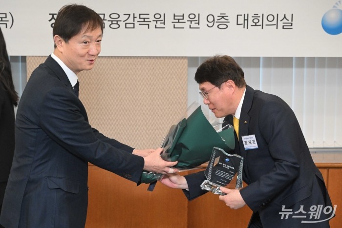 (왼쪽)이찬진 금융감독원장이 29일 오후 서울 여의도 금융감독원 본원에서 열린 제7회 '상생협력 금융新상품' 우수사례 시상식에서 김재관 KB국민카드 대표이사에게 우수기관 상패를 수여한 뒤 꽃다발을 전달하고 있다. 사진=강민석 기자 kms@newsway.co.kr