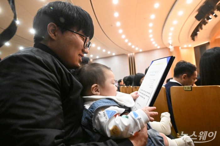 부영그룹의 직원과 자녀가 5일 오전 서울 중구 부영태평빌딩에서 열린 자사 시무식(출산장려지원 및 19단 경연대회)에 참석해 출산장려금 지급증서를 보고 있다. 사진=강민석 기자 kms@newsway.co.kr