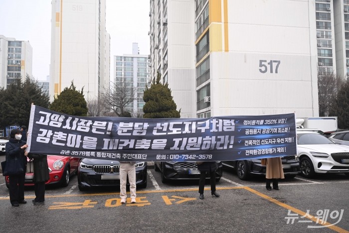 강촌 3578 통합재건축 주민대표단이 11일 오전 경기 고양시 1기 신도시 정비사업 선도지구를 찾아 강촌마을 재건축 지원을 촉구하는 현수막을 들고 있다. 이날 김윤덕 국토교통부 장관이 선도지구 현장을 점검했다. 사진=강민석 기자 kms@newsway.co.kr