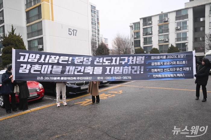 강촌 3578 통합재건축 주민대표단이 11일 오전 경기 고양시 1기 신도시 정비사업 선도지구를 찾아 강촌마을 재건축 지원을 촉구하는 현수막을 들고 있다. 이날 김윤덕 국토교통부 장관이 선도지구 현장을 점검했다. 사진=강민석 기자 kms@newsway.co.kr