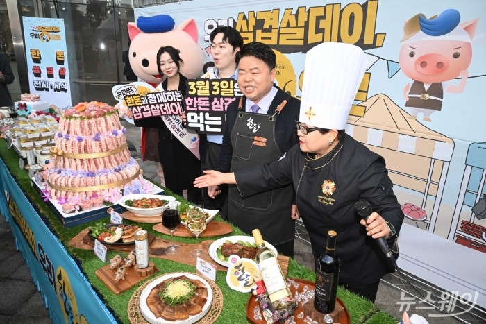 (오른쪽 두 번째)이기홍 한돈자조금관리위원회 위원장이 27일 오전 서울 종로구 청계천로 인근에서 열린 '우리 삼겹살데이 우리 한돈으로' 소비촉진 행사에서 한돈 요리사의 설명을 경청하고 있다. 사진=강민석 기자 kms@newsway.co.kr