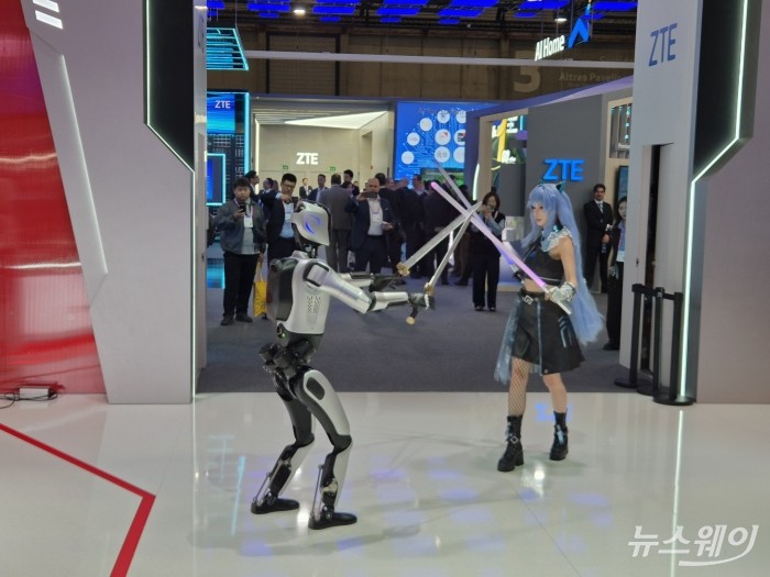 지난 4일(현지시간)MWC26에 참여한 중국 통신장비 기업 ZTE의 부스에서 로봇과 캐릭터 분장한 모델이 칼 싸움을 벌이고 있다. 사진=유선희 기자