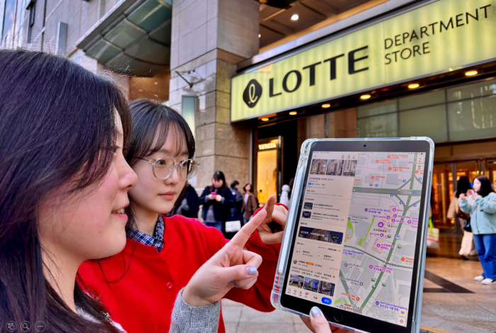 서울시 중구 소공동에 위치한 롯데백화점 본점 앞에서 두 모델이 '가오더 디튜' 앱을 사용하고 있다/사진=롯데백화점 제공