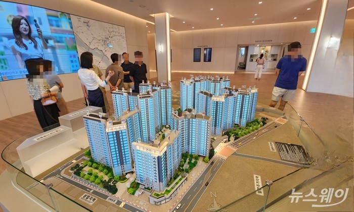 수도권 한 아파트 모델하우스에 마련된 단지 모형도를 관람객들이 둘러보고 있다. 사진=권한일 기자