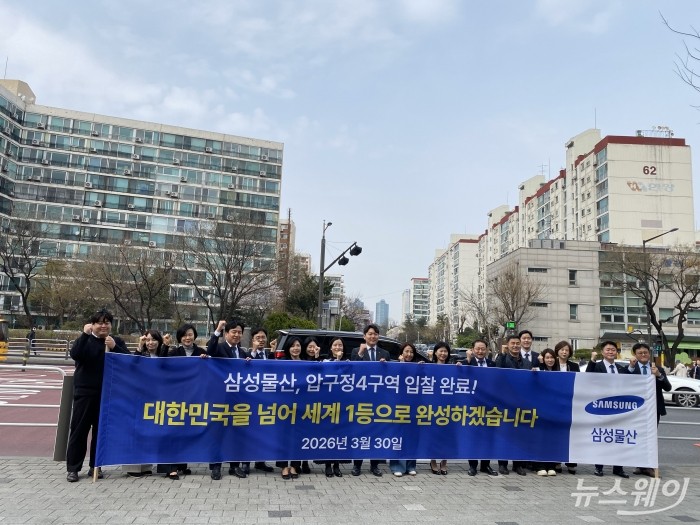 삼성물산 관계자들이 30일 압구정4구역 앞에서 현수막을 들고 사진을 찍고있다. 사진=이재성 기자