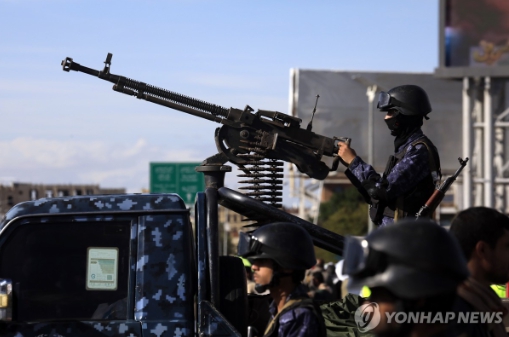 27일(현지시간) 예멘 수도 사나에서 후티 반군 지지자들이 이란 지지 집회를 여는 가운데 후티 무장대원이 기관총을 들고 섰다. 사진=사나 EPA 연합뉴스