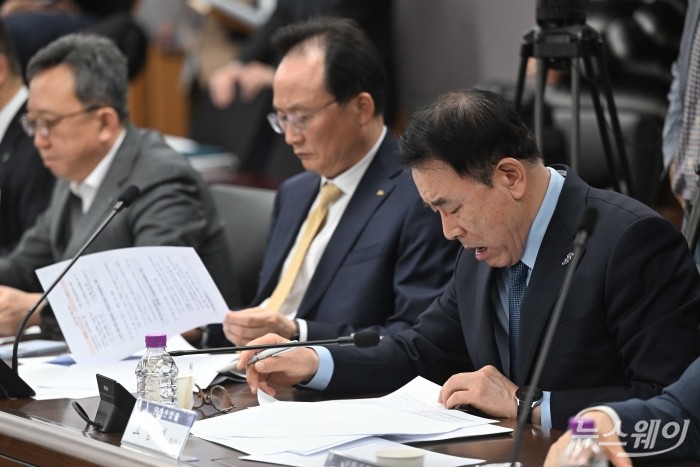 (오른쪽 첫 번째)조용병 전국은행연합회장이 1일 오전 서울 종로구 정부서울청사에서 열린 가계부채 점검회의에 참석해 이억원 금융위원장의 모두발언을 경청하며 자료를 살펴보고 있다. 사진=강민석 기자 kms@newsway.co.kr