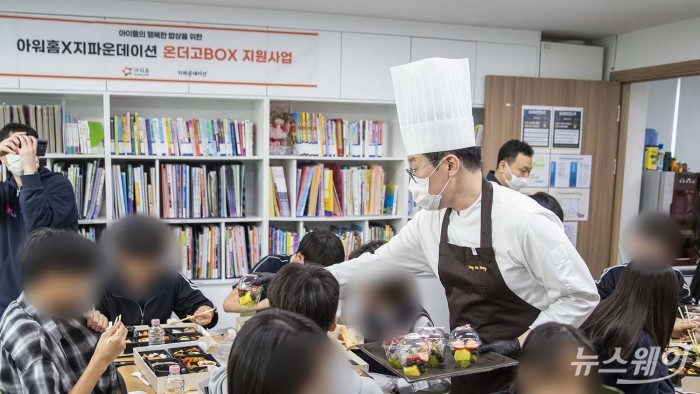 서울 도봉구 씨앗지역아동센터에 배달된 온더고 BOX를 배급하는 모습. 사진제공=아워홈.