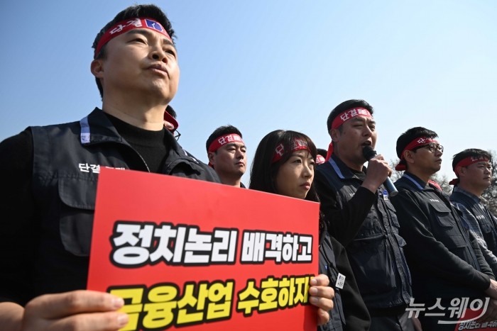 윤석구 전국금융산업노동조합 위원장이 2일 오전 서울 종로구 청와대 분수대 앞에서 열린 '정치적 지방이전 저지'와 '금융경쟁력 사수'를 위한 기자회견에서 손팻말을 들고 있다. 사진=강민석 기자 kms@newsway.co.kr