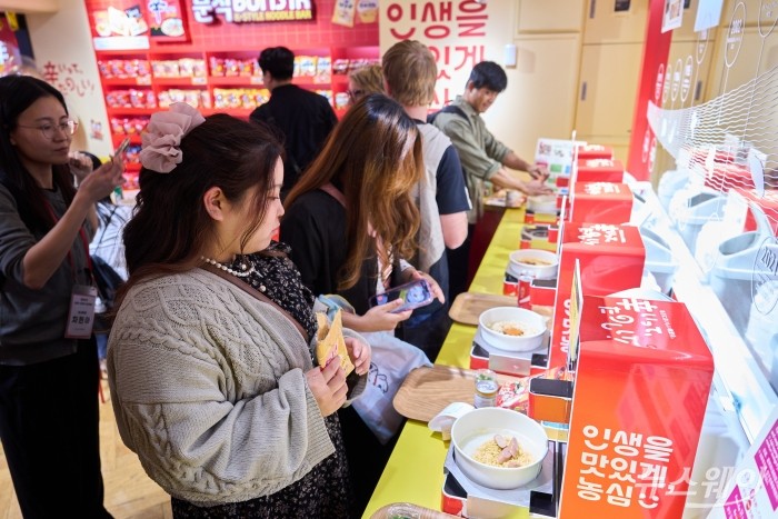 지난 16일 일본 도쿄 하라주쿠에 위치한 '신라면분식'을 방문한 일본 소비자들이 한강 라면 기계를 통해 직접 신라면을 제조하고 있다. 사진=농심