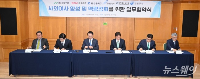 (오른쪽 세 번째)이찬진 금융감독원장과 (왼쪽 세 번째)조용병 은행연합회장을 비롯한 참석자들이 28일 오전 서울 중구 은행회관에서 열린 '사외이사 양성 및 역량 강화를 위한 업무협약식'에서 협약서에 서명을 하고 있다. (왼쪽부터)김기홍 JB금융지주 회장, 빈대인 BNK금융지주 회장, 조 은행연합회장, 이 금감원장, 황병우 IM금융지주 회장, 이준수 한국금융연수원장. 사진=강민석 기자