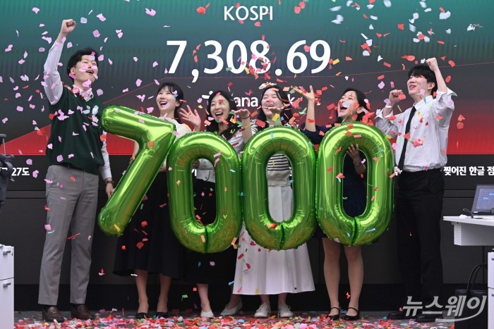 코스피가 사상 처음 7000선을 넘어선 6일 오전 서울 중구 하나은행 딜링룸에서 딜러들이 세리모니를 하고 있다. 이날 코스피는 오전 9시 3분 전 거래일보다 374.66포인트(5.40%) 오른 7311.54를 기록하며 장중 최고치를 새로 썼다. 사진=강민석 기자