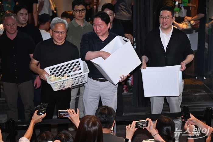 (왼쪽 첫 번째)젠슨 황 엔비디아 창립자 겸 최고경영자와 최태원 SK그룹 회장, 구광모 LG그룹 회장이 5일 오후 서울 마포구 형님저요 고깃집에서 '삼겹살 회동'을 즐기던 중 잠시 야외로 나와 준비한 선물을 시민들에게 전달하고 있다. 사진=강민석 기자