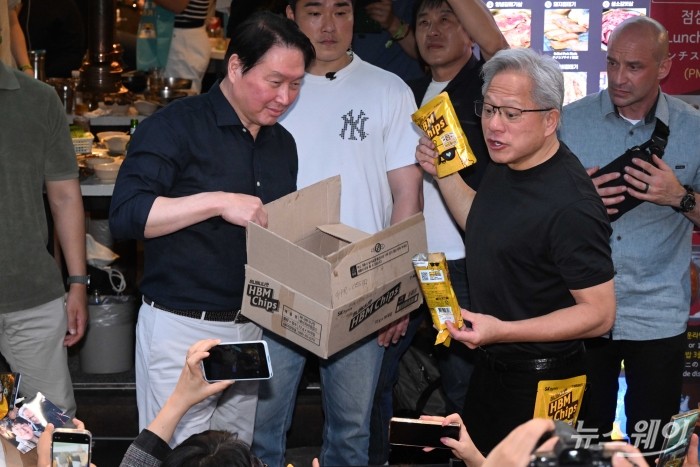 (오른쪽)젠슨 황 엔비디아 창립자 겸 최고경영자와 최태원 SK그룹 회장이 5일 오후 서울 마포구 형님저요 고깃집에서 구광모 LG그룹 회장, 이해진 네이버 의장과 '삼겹살 회동'을 즐기던 중 잠시 야외로 나와 'HBM 칩스'를 시민들에게 선물해주고 있다. 사진=강민석 기자