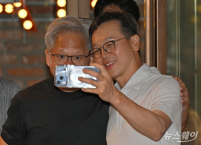젠슨 황 엔비디아 최고경영자(CEO)가 7일 서울 강남구 깐부치킨에서 열린 최태원 SK그룹 회장과의 '치맥 회동'에서 김주선 SK하이닉스 인공지능(AI) 인프라담당 사장과 휴대폰 '셀피'를 찍고 있다. 사진=이수길 기자