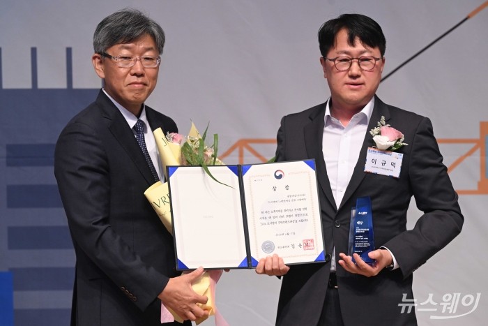 (왼쪽)김이탁 국토교통부 제1차관이 17일 오후 서울 중구 한국프레스센터에서 열린 뉴스웨이 '2026 도시정비 주택브랜드대상' 시상식에서 이규덕 DL이앤씨 주택사업본부 담당에게 종합대상 수도권 부문 국토교통부 장관상을 수여한 뒤 기념촬영을 하고 있다. 사진=강민석 기자