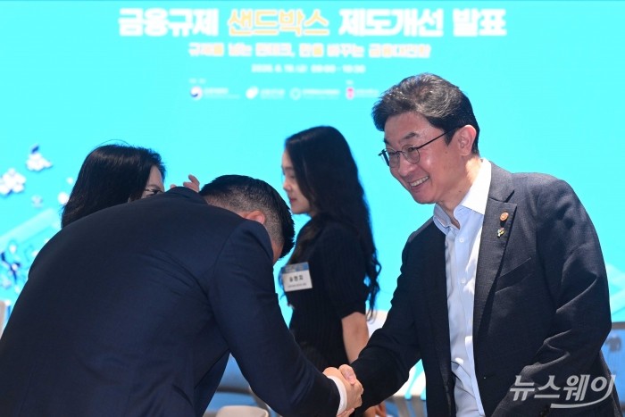 이억원 금융위원장이 19일 오전 경기 성남시 서강대학교 판교디지털혁신캠퍼스 기술경영전문대학원에서 열린 샌드박스 제도개선 발표에서 참석자과 악수하고 있다. 사진=강민석 기자