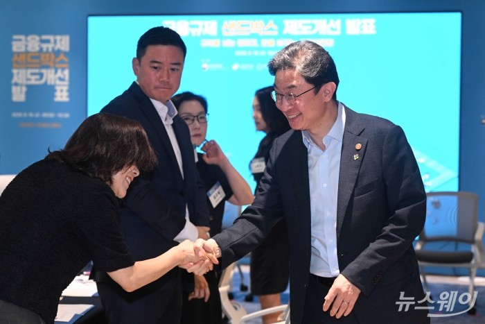 이억원 금융위원장이 19일 오전 경기 성남시 서강대학교 판교디지털혁신캠퍼스 기술경영전문대학원에서 열린 샌드박스 제도개선 발표에서 참석자과 악수하고 있다. 사진=강민석 기자