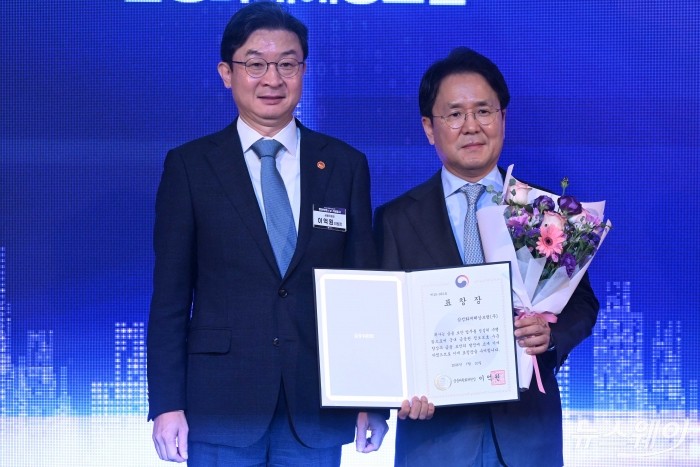 (왼쪽)이억원 금융위원장이 10일 오전 서울 종로구 포시즌스 호텔에서 열린 정보보호의 날 기념식에서 이문화 삼성화재해상보험 대표이사에게 유공자 표창을 수여한 뒤 기념촬영을 하고 있다. 사진=강민석 기자