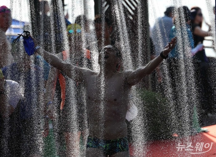 12일 오전 서울 송파구 잠실 석촌호수에서 열린 '2026 롯데 아쿠아슬론(2026 LOTTE AQUATHLON)'에서 참가자가 도착지점을 지나가고 있다. 사진=강민석 기자