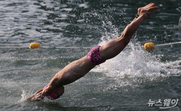 12일 오전 서울 송파구 잠실 석촌호수에서 열린 '2026 롯데 아쿠아슬론(2026 LOTTE AQUATHLON)'에서 참가자가 힘차게 다이빙을 하고 있다. 사진=강민석 기자