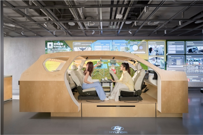 UX 테스트 존에 전시된 나무로 만든 스터디 벅(Study Buck)에서 방문객들이 마주 앉아 대면 모드를 체험하는 모습. 사진=현대차그룹