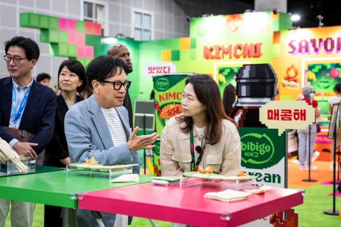 KCON LA 2026을 방문한 CJ 이재현 회장이 비비고 부스에서 미니완탕과 김치 라면을 맛보고 있다. 사진=CJ