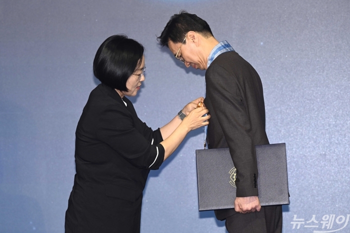 한성숙 국무총리가 7일 오후 서울 여의도 페어몬트 앰배서더 호텔에서 열린 기술개발인의날 기념식에서 이진엽 삼성전자 부사장에게 과학기술훈장 혁신장을 전수하고 있다. 사진=강민석 기자
