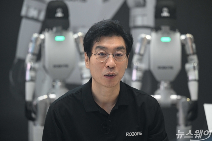 김병수 로보티즈 대표가 22일 오후 서울 강남구 코엑스 그랜드볼룸에서 진행된 '휴머노이드 서밋 2026'에 마련된 자사 부스에서 관람객에게 상체형 휴머노이드 로봇 플랫폼 'AI 워커(AI Worker)'와 완성형 이족 보행 휴머노이드 'AI 사피엔스'를 소개하고 있다. 사진=강민석 기자