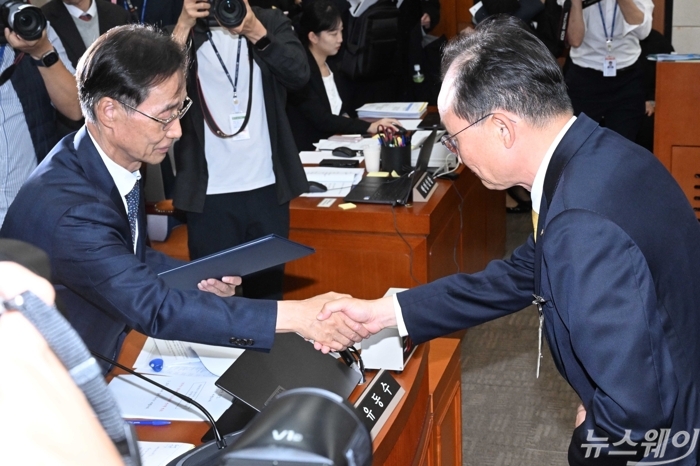 이환주 KB국민은행장이 증인선서를 마친 뒤 유동수 정무위원장에게 선서문을 전달하고 있다. 사진=강민석 기자