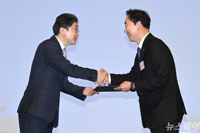 이억원 금융위원장이 27일 오전 서울 중구 웨스틴조선호텔에서 열린 제11회 금융의 날 기념식에서 조대규 교보생명 대표이사에게 표창장을 수여한 뒤 악수하고 있다. 사진=강민석 기자